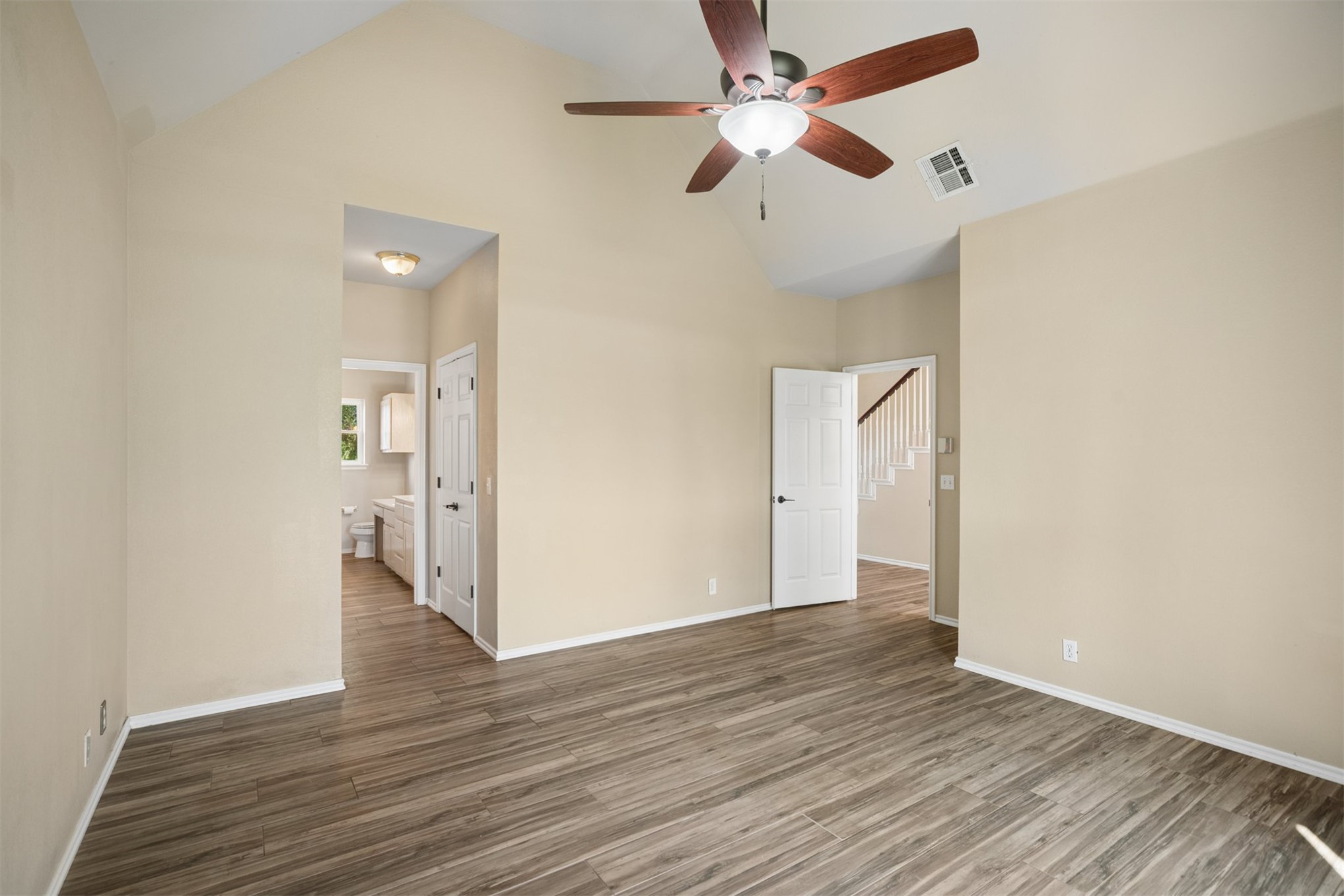 175 Alt 75 Mounds, OK 74047 - Photo 9 of 41 Vaulted ceiling, wood-finish flooring, ceiling fan with integrated lighting, white interior doors, and white stair railing