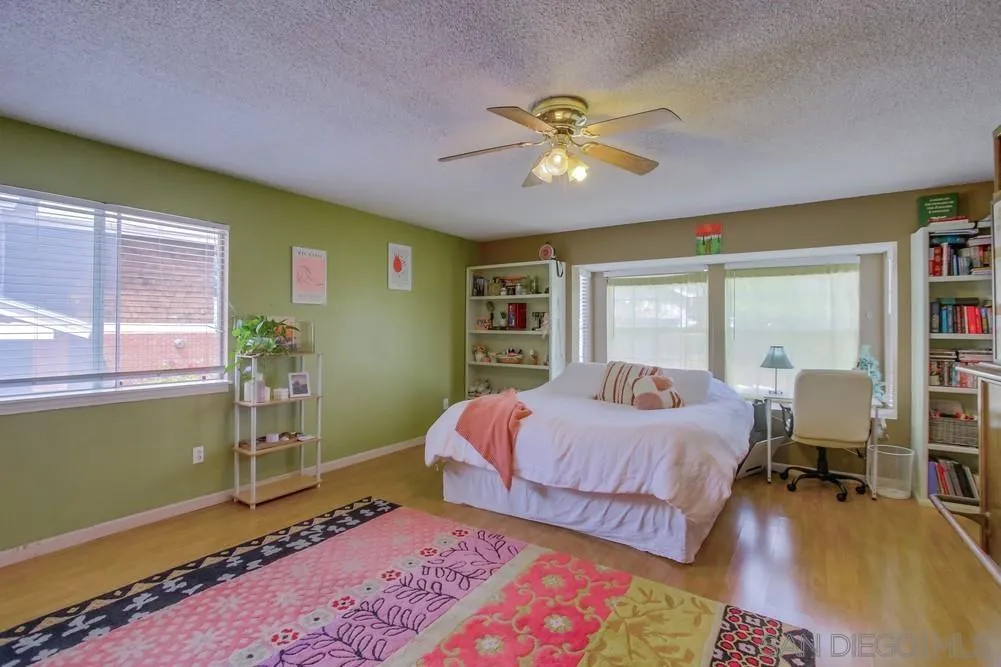 13590 Freeport Road San Diego, CA 92129 - Photo 44 of 58 a bedroom with a bed and wooden floor
