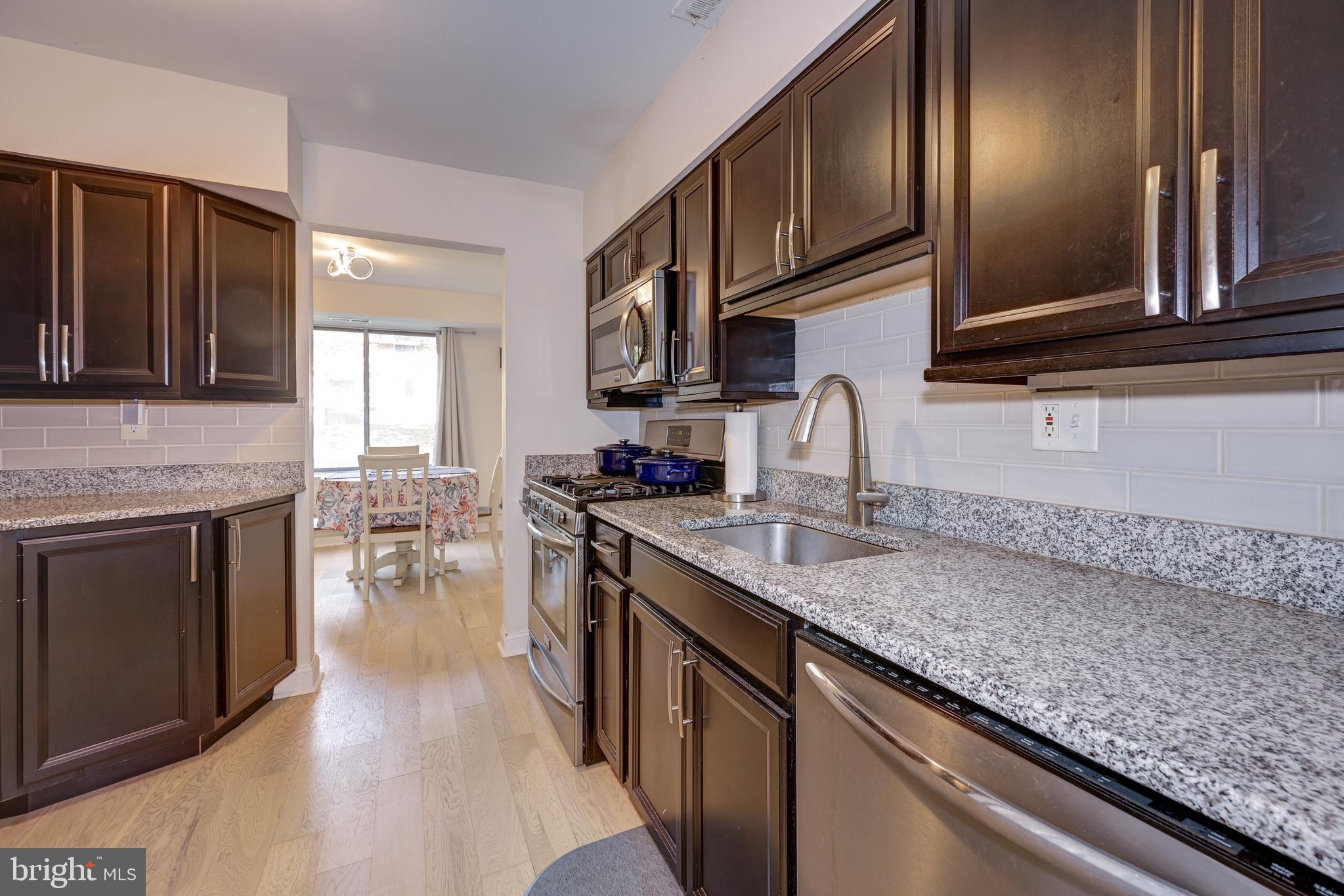 126 Kirkbride Road Voorhees, NJ 08043 - Photo 4 of 25 a kitchen with stainless steel appliances granite countertop a sink stove and cabinets
