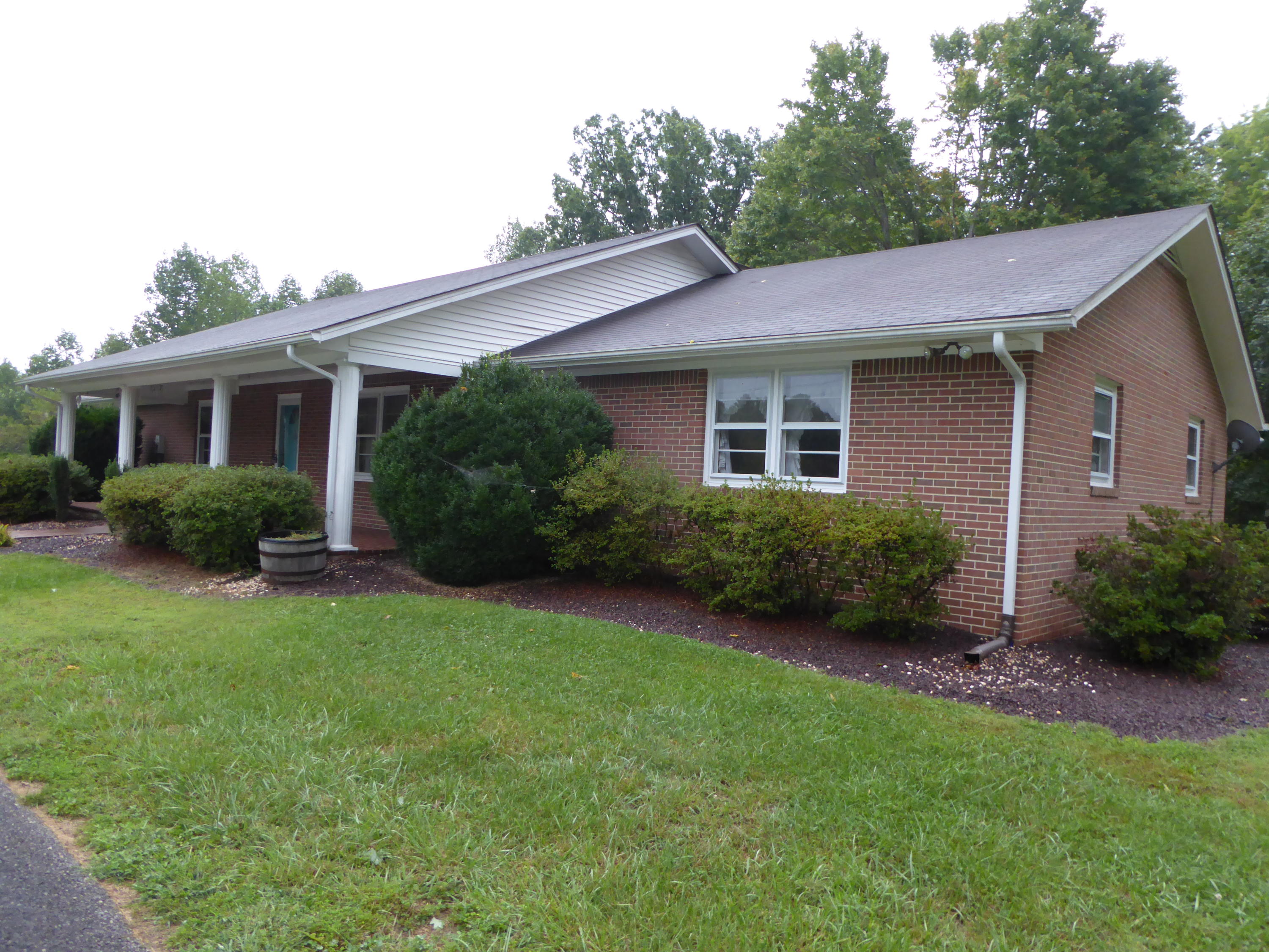 10454 Henry Road Henry, VA 24102 - Photo 2 of 72 a view of a house with brick walls and a yard with plants