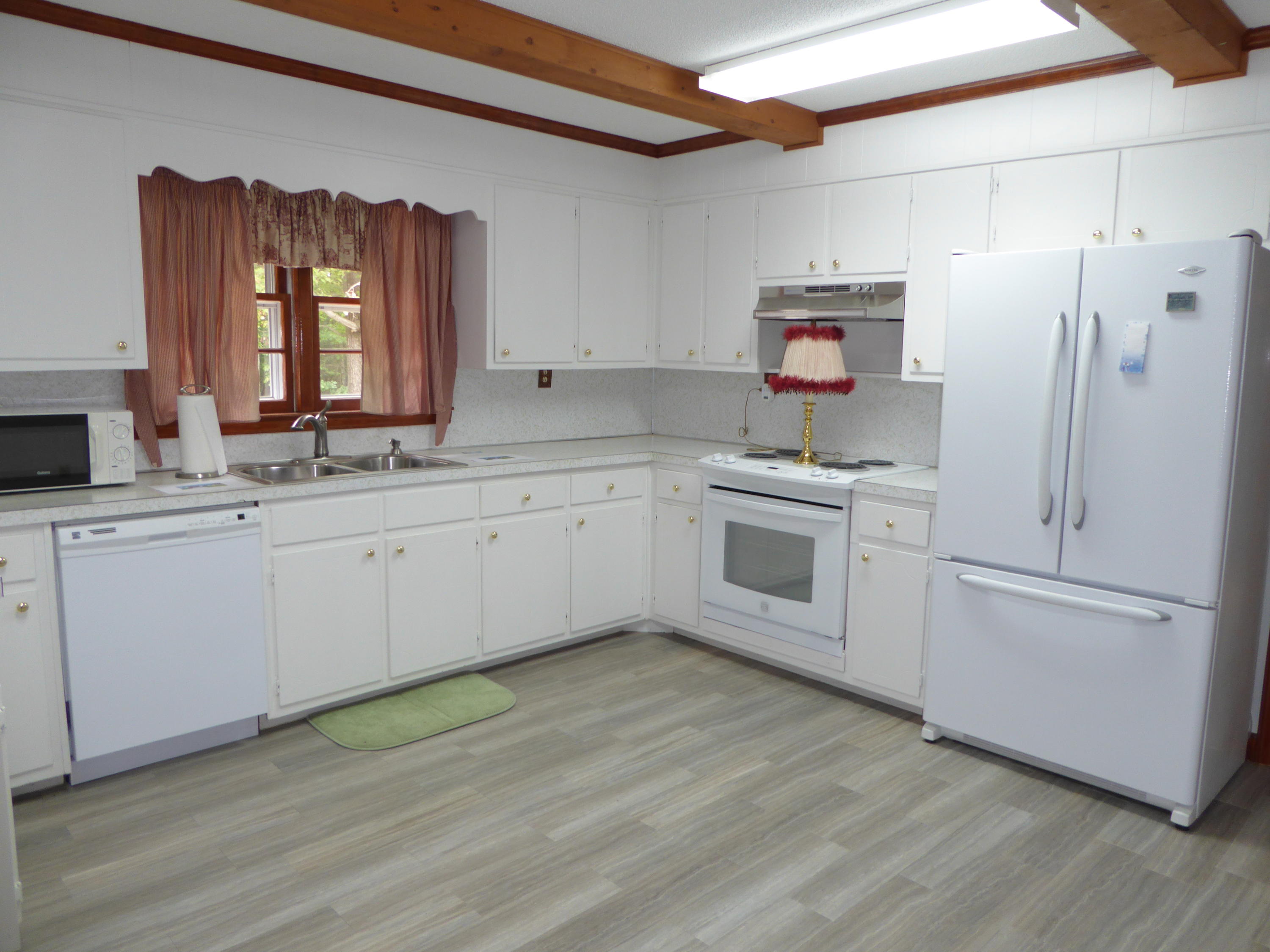 10454 Henry Road Henry, VA 24102 - Photo 10 of 72 a kitchen with white cabinets and white appliances