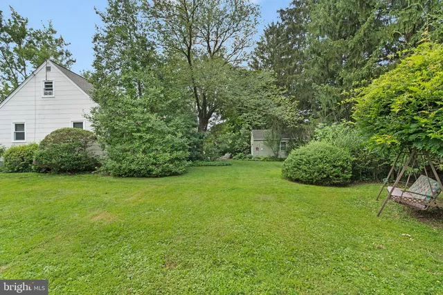 a sign that is sitting in front of a house with wooden fence