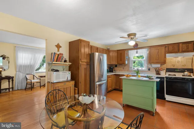 a kitchen with a refrigerator a sink cabinets and wooden floor