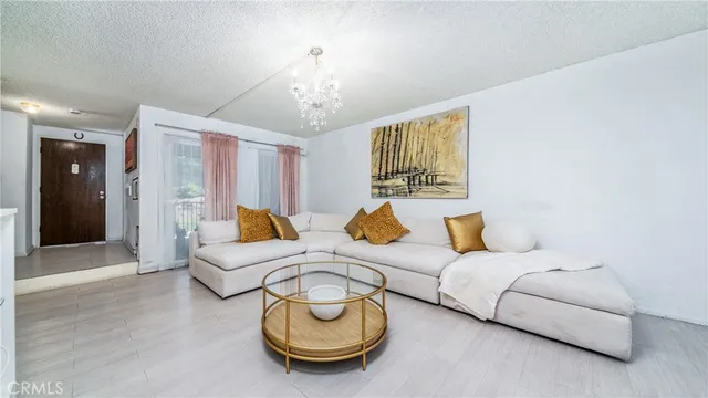 a living room with furniture and a chandelier