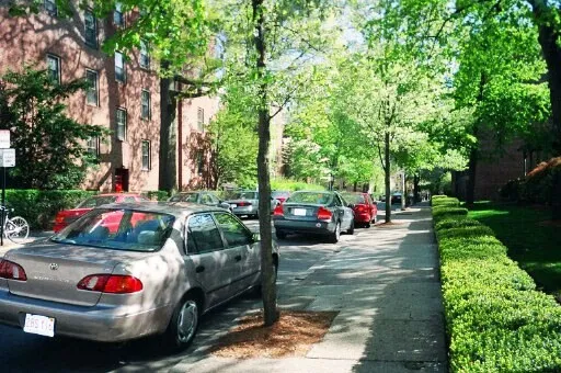 a view of a street with cars parked on the roadside