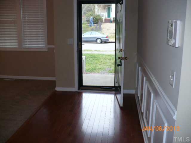 2512 Spruce Shadows Lane Raleigh, NC 27614 - Photo 3 of 22 a view of an empty room with wooden floor and a window