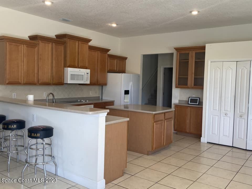 1633 Long Pine Road Melbourne, FL 32940 - Photo 4 of 12 a kitchen with cabinets and chairs