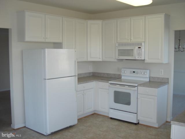 7305 Maplecrest Road, Unit 403 Elkridge, MD 21075 - Photo 12 of 30 a white refrigerator freezer sitting inside of a kitchen