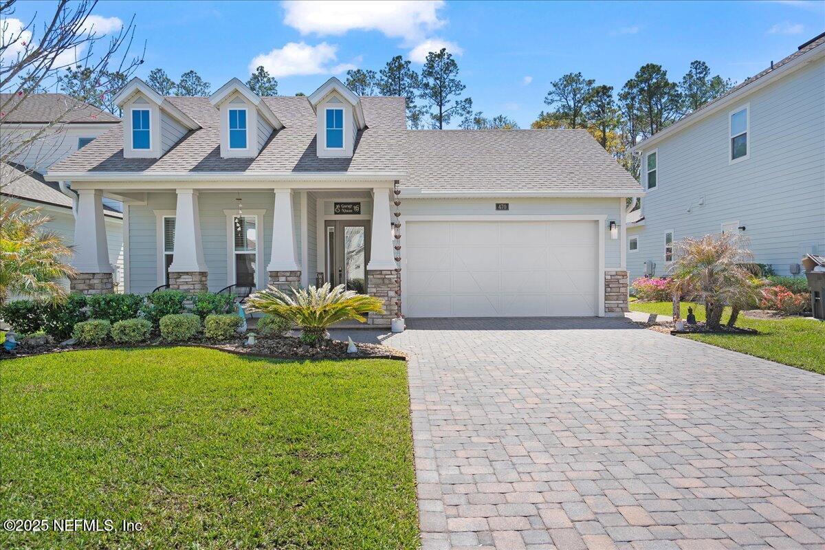 a front view of a house with a yard and a garage