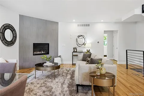 a living room with furniture a flat screen tv and a wall clock