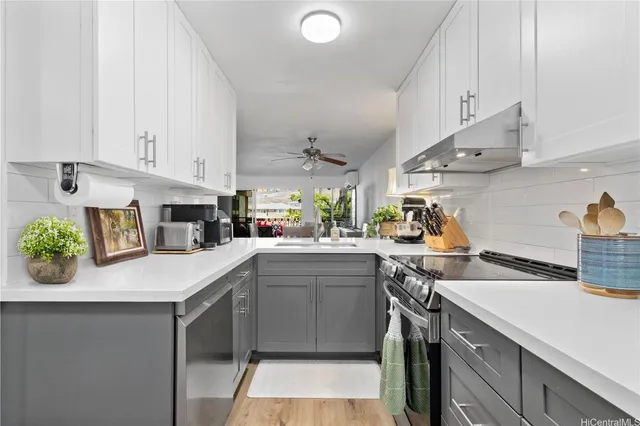 a kitchen with granite countertop a sink stainless steel appliances and cabinets