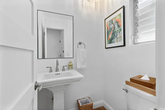 a bathroom with a toilet a sink and mirror