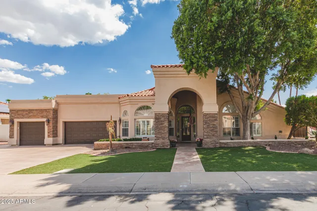 a front view of a house with a garden and trees