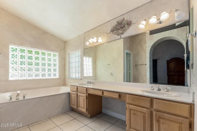 a bathroom with a granite countertop sink mirror and bathtub