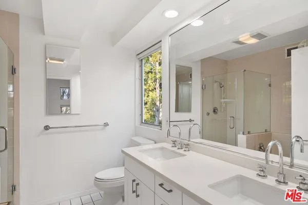 a bathroom with a granite countertop toilet a sink and a mirror