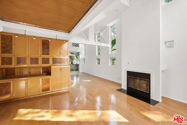 a view of a livingroom with wooden floor and a fireplace