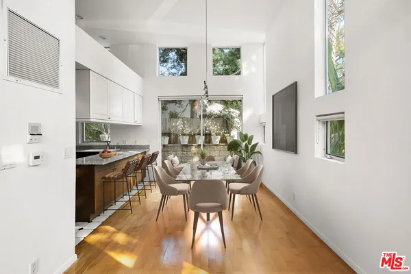 a dining room with furniture a chandelier and wooden floor