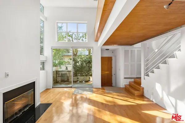 a view of an empty room with a fireplace and a window