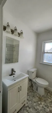 a bathroom with a sink a toilet and mirror