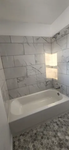 a bathroom with a bathtub and a shower