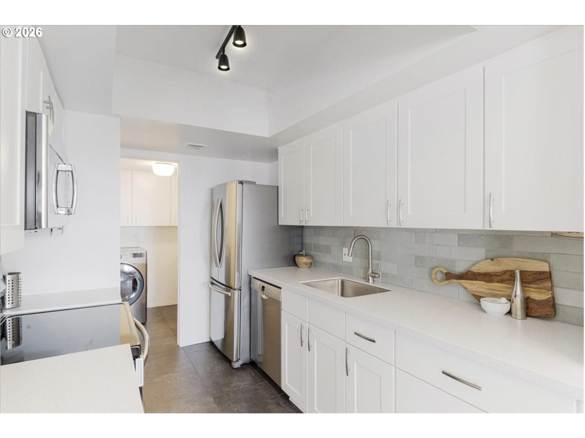 6645 West Burnside Street, Unit 550 Portland, OR 97225 - Photo 6 of 38 a kitchen with stainless steel appliances granite countertop a sink refrigerator and microwave