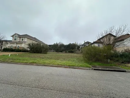 a view of a house with a yard and a large parking space