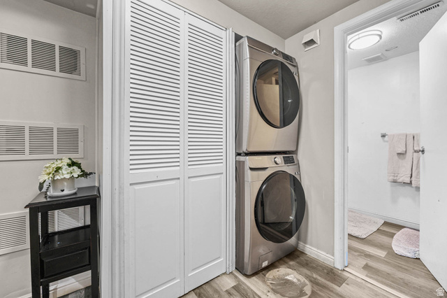 7609 Mountain View Road Lake Point, UT 84074 - Photo 13 of 16 Washroom featuring light wood-type flooring and stacked washing machine and dryer