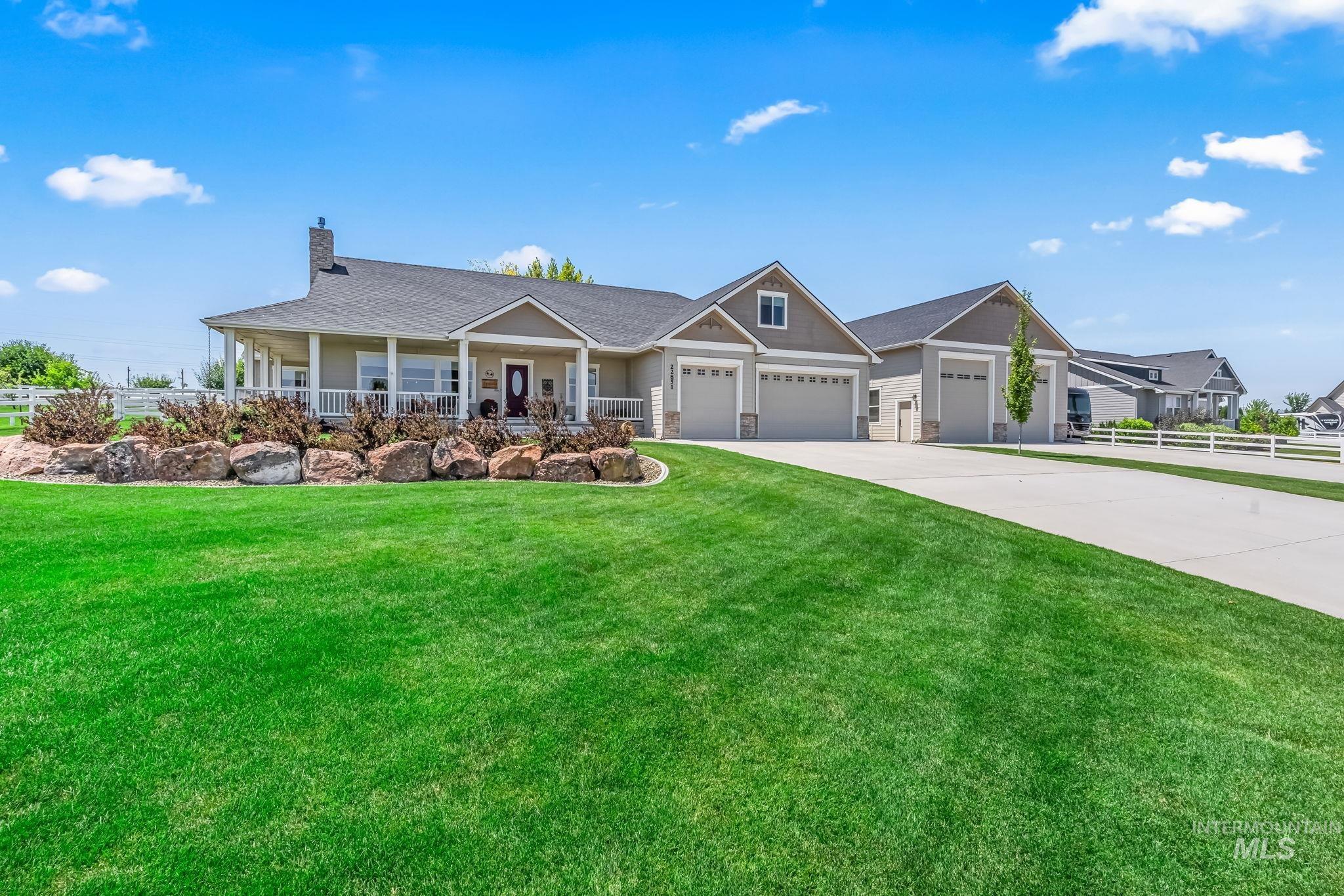 22851 Rosicky Way Caldwell, ID 83607 - Photo 1 of 1 View of front of property featuring covered porch, concrete driveway, a garage, and a chimney