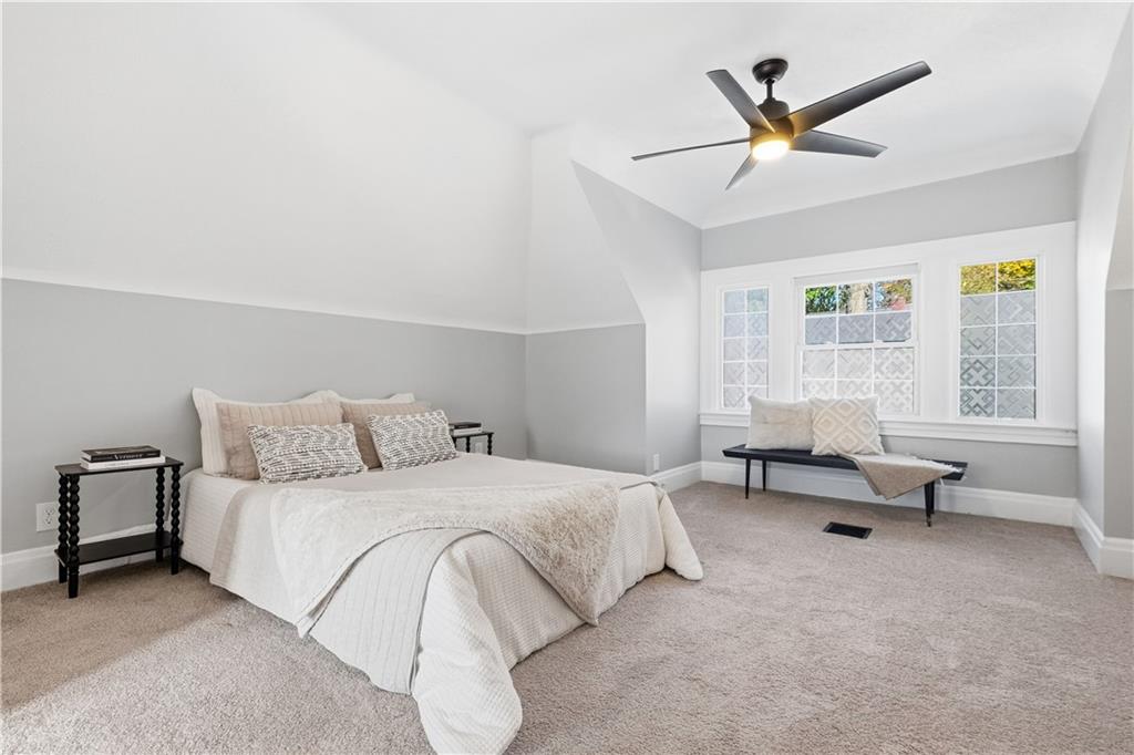 210 Elm Street Pittsburgh, PA 15218 - Photo 27 of 36 a spacious bedroom with a bed a couch and a window