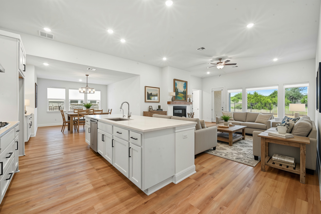 433 Running Bird Road Austin, TX 78737 - Photo 4 of 40 An open concept living area seamlessly blends kitchen, dining, and family spaces with warm wooden floors and abundant natural light.