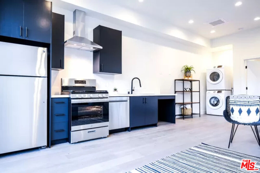 321 North Bixel Street, Unit 2 Los Angeles, CA 90026 - Photo 2 of 22 a kitchen with stainless steel appliances a stove a refrigerator and a sink with wooden floor