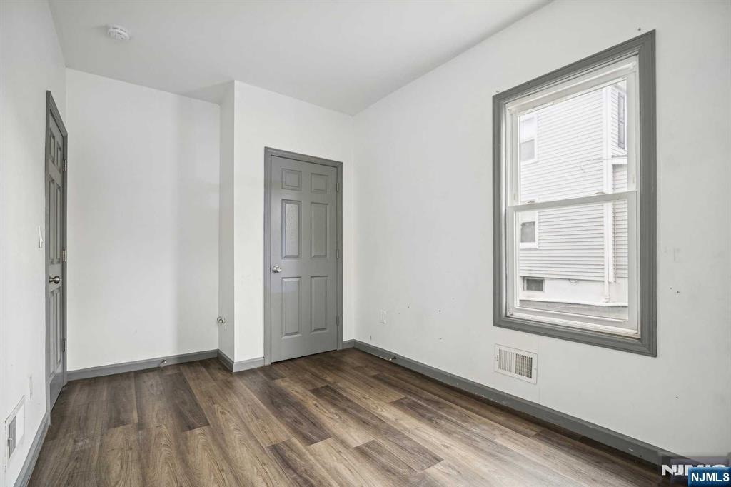 143 Valley Road, Unit 1R Montclair, NJ 07042 - Photo 10 of 18 a view of an empty room with wooden floor and a window