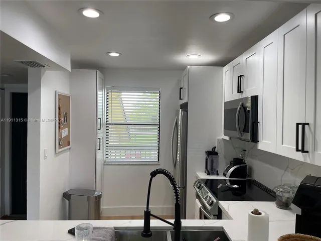 a kitchen with stainless steel appliances granite countertop a refrigerator and a stove top oven