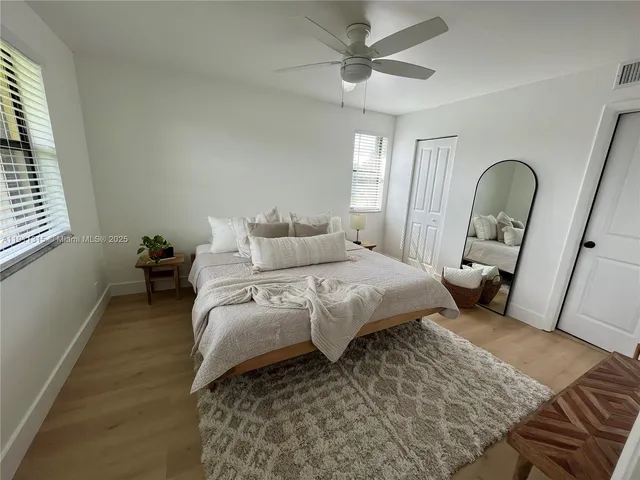 a view of a room that has a window and a ceiling fan
