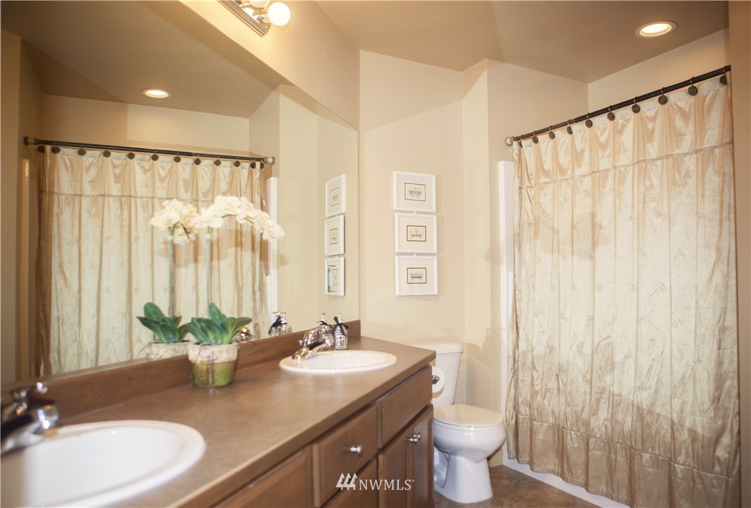 3808 186th Street Southeast Bothell, WA 98012 - Photo 21 of 25 a bathroom with a granite countertop sink a toilet and a mirror