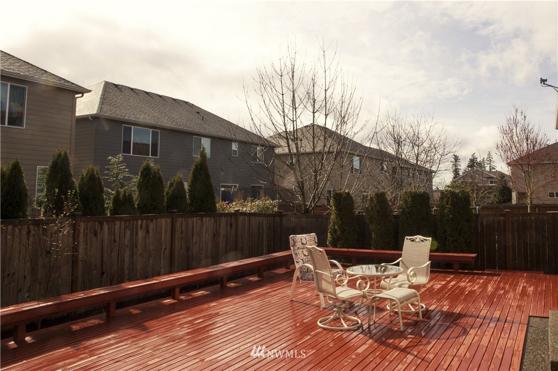 3808 186th Street Southeast Bothell, WA 98012 - Photo 25 of 25 a view of a roof deck with table and chairs a barbeque with wooden floor and fence