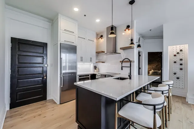 a kitchen with stainless steel appliances a refrigerator and a stove top oven