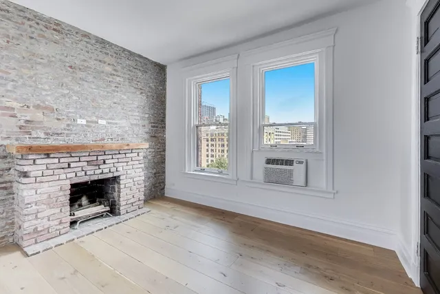 a view of walk in closet with wooden floor and windows