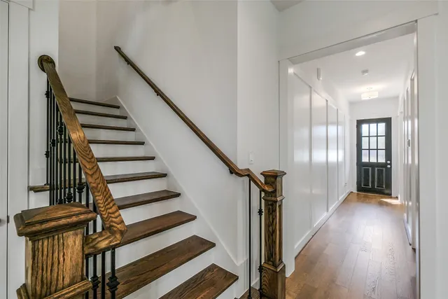a view of a hallway with wooden floor and staircase