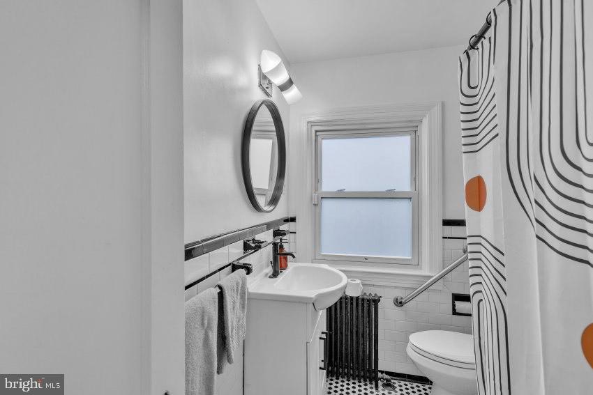 3310 Elbert Street Baltimore, MD 21229 - Photo 18 of 23 a bathroom with a sink a toilet and mirror