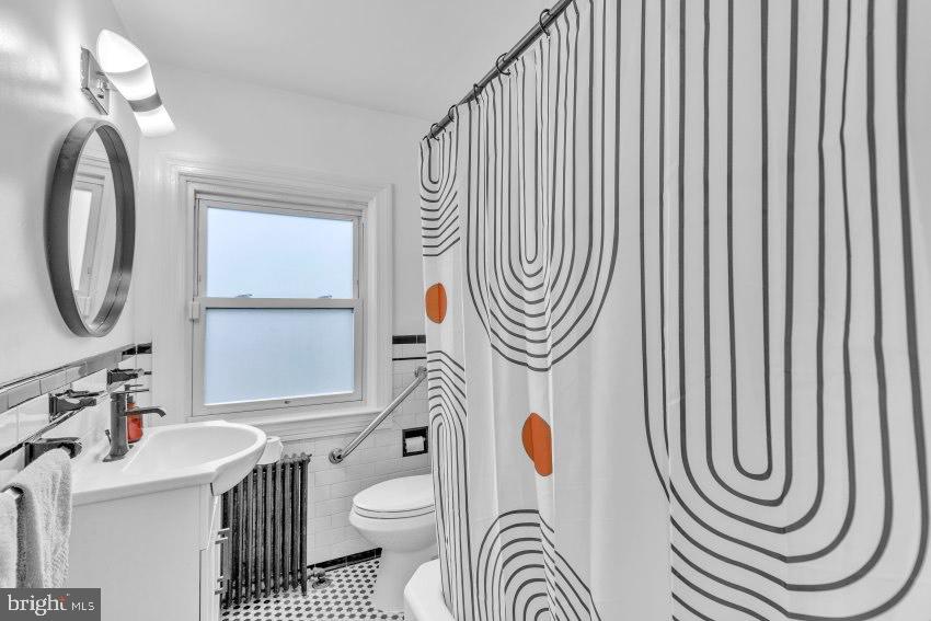 3310 Elbert Street Baltimore, MD 21229 - Photo 19 of 23 a bathroom with a sink a mirror and a window