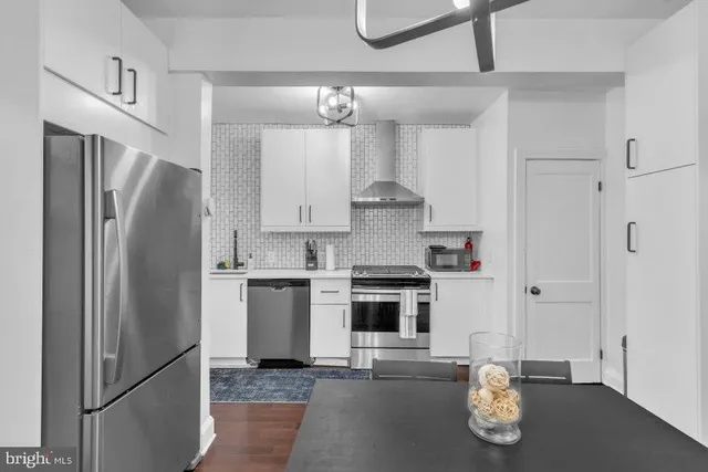 a kitchen with stainless steel appliances granite countertop a refrigerator sink and stove