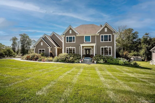 a front view of a house with yard and green space