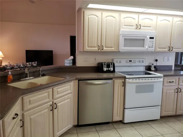 a kitchen with cabinets appliances a sink and a stove