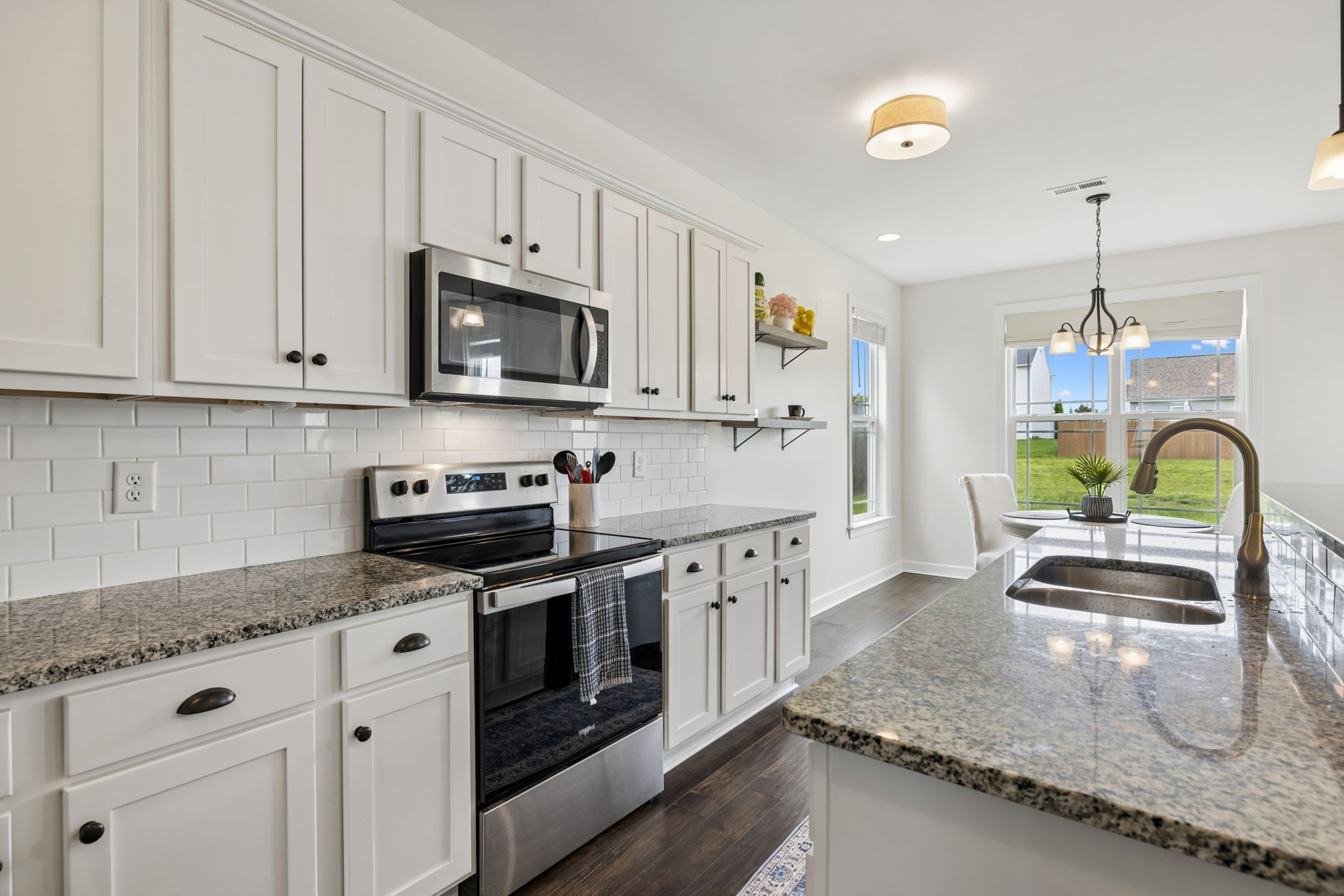 1002 Garrison Way Spring Hill, TN 37174 - Photo 26 of 63 a kitchen with granite countertop a sink a stove and cabinets