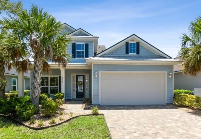 a front view of a house with a yard and potted plants