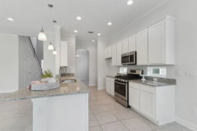 a kitchen with granite countertop a sink a toilet and cabinets