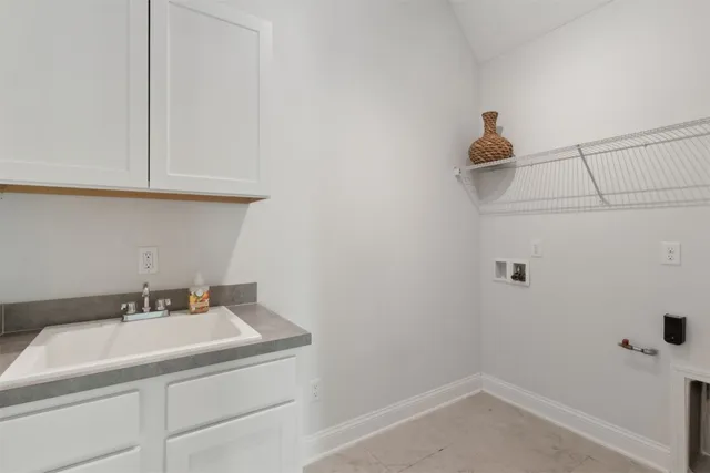 an empty room with a chandelier fan and windows