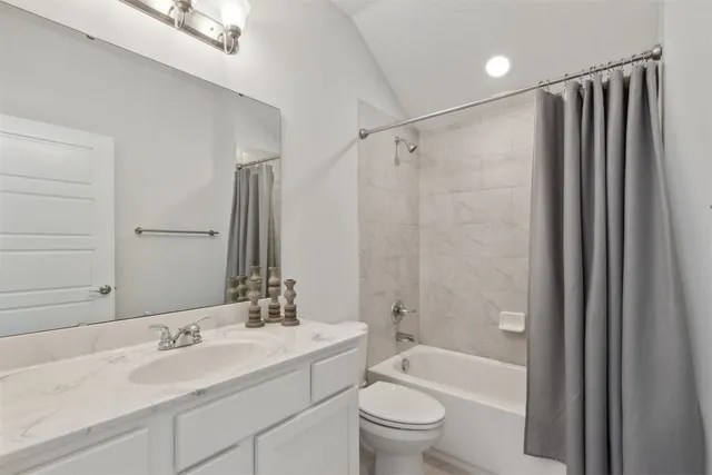 an empty room with chandelier fan and windows