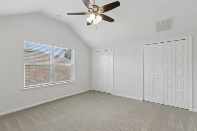 an empty room with a window and a fan